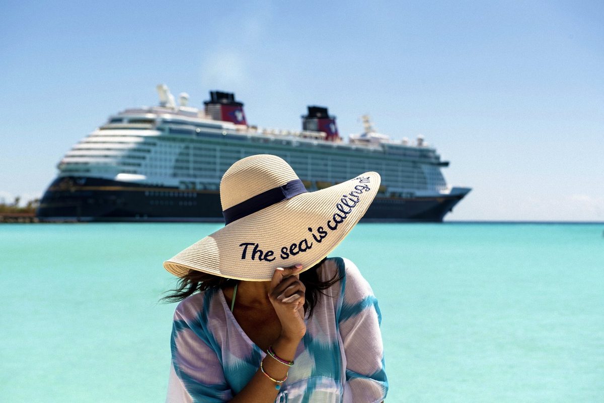 A Disney Cruise Line ship anchored off a turquoise Caribbean beach