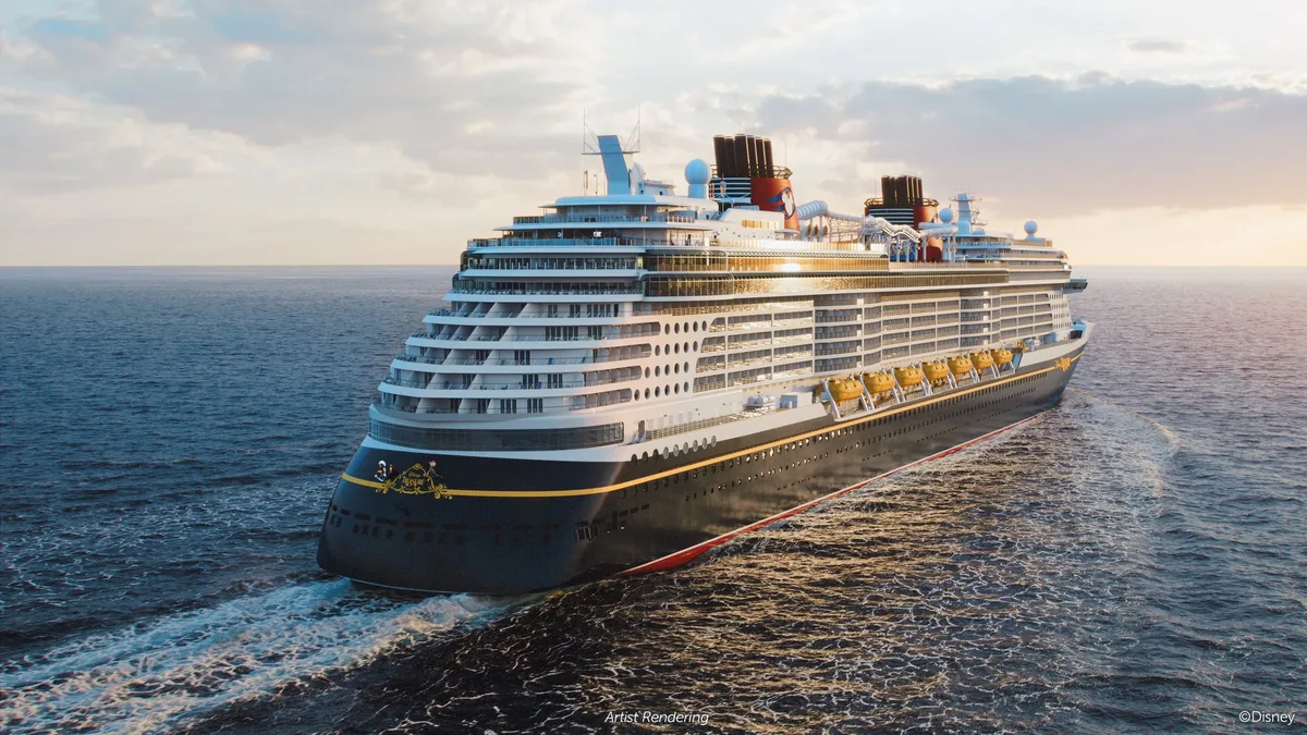 The Disney Treasure cruise ship sailing on the open ocean at sunset
