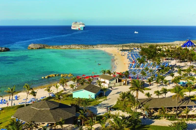 A Norwegian Cruise Line ship anchored off a Bahamas beach island