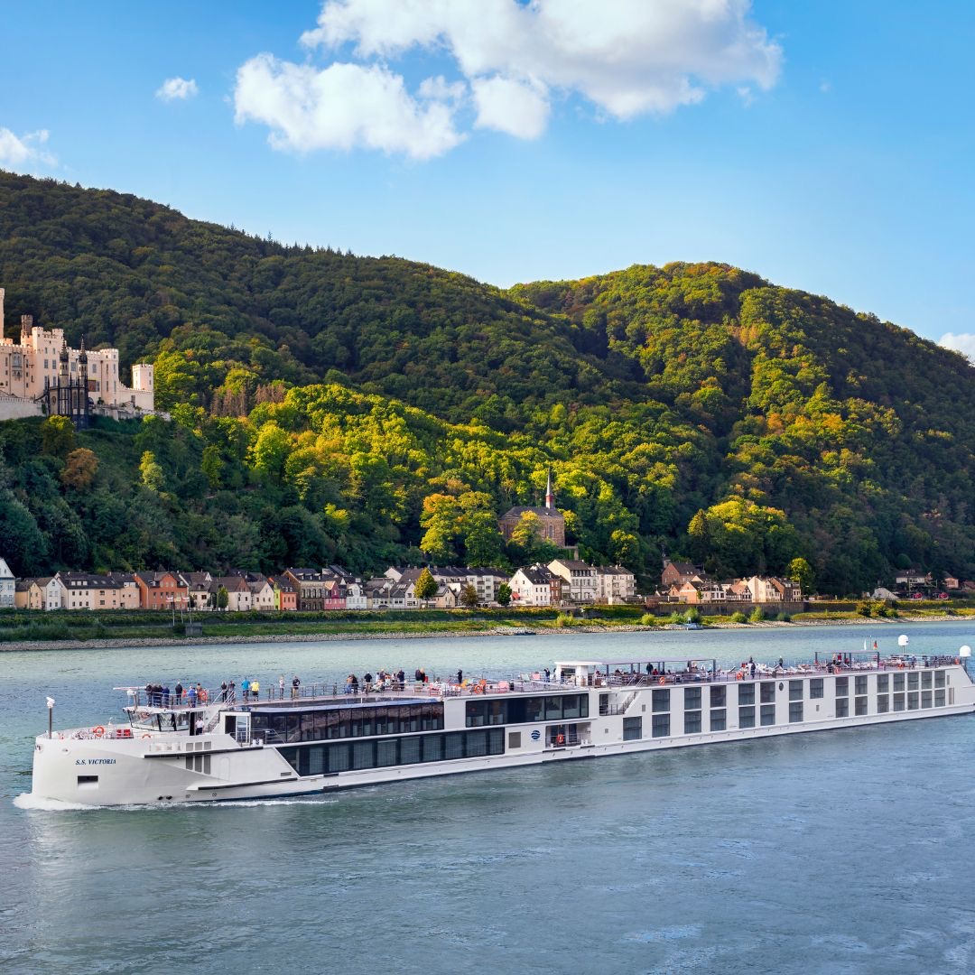 The Uniworld river ship S.S. Victoria cruising the Rhine past a hilltop castle